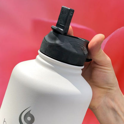 Black straw lid on white bottle, upright cap and side straw opening.